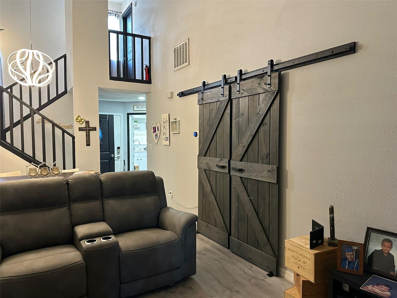 Look from the living room to the upstairs- Barn doors are the entrance to the downstairs bedroom