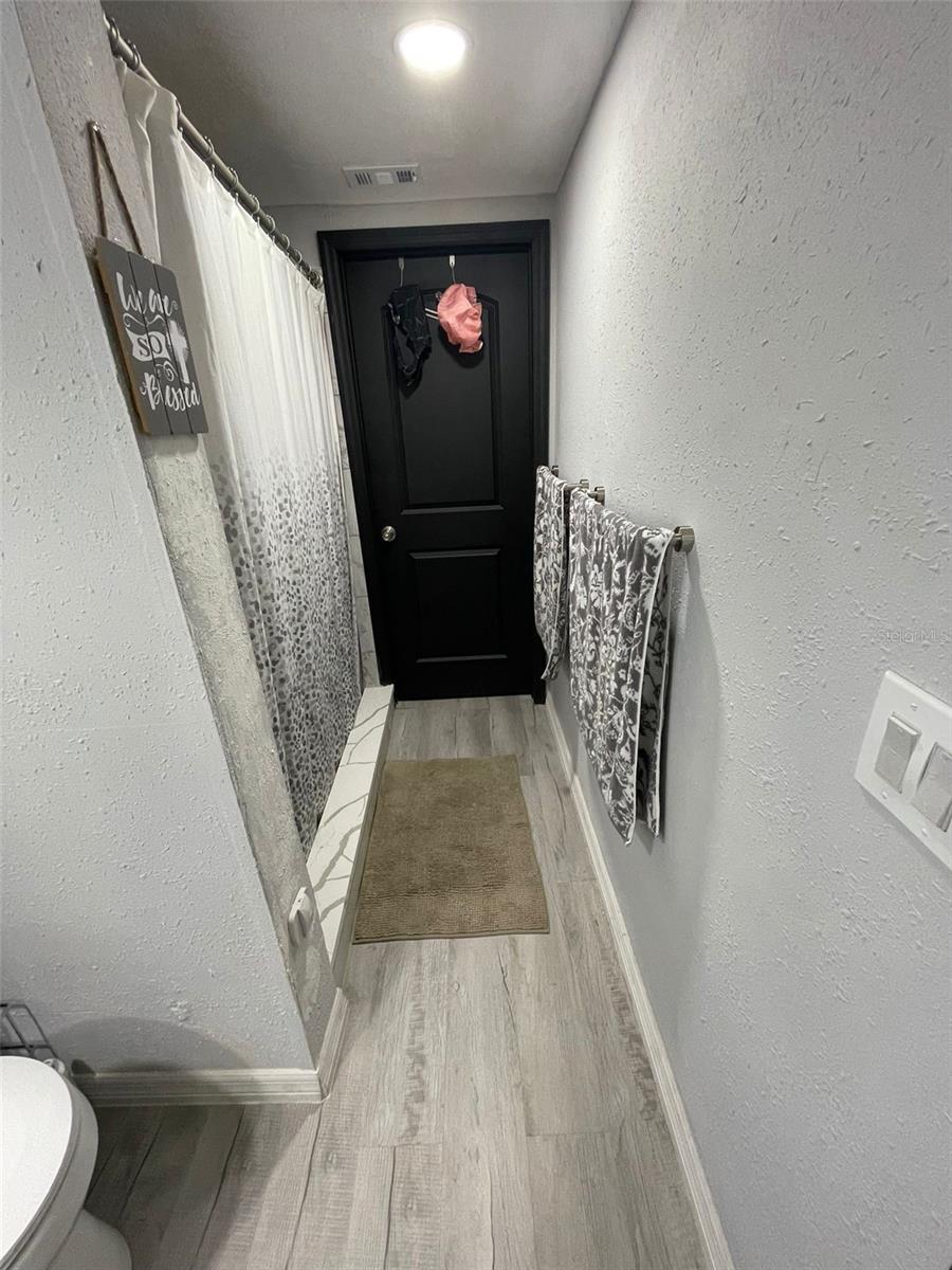 Look of the door towards the downstairs bedroom from inside the bathroom