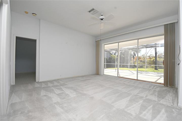 The living room has wall-to-wall sliding glass doors that open to the screened in lanai.