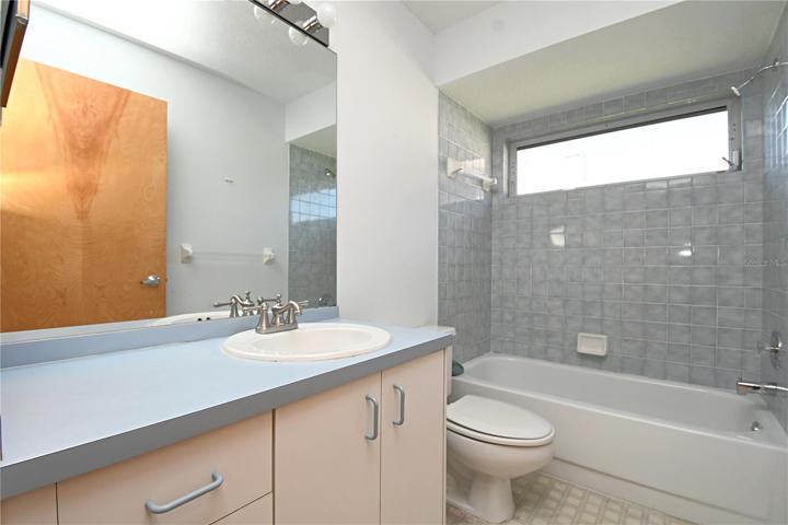 Bathroom 2 features a single sink vanity and tub with shower. It is located in between bedrooms 3 and 4.