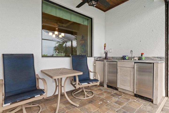 Lanai space has kitchen area with sink, fridge, and set up for kegerator.