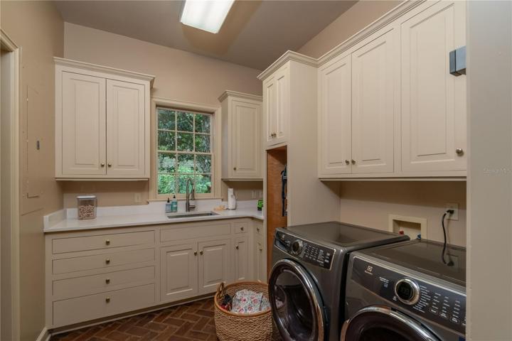 Laundry room with built-in cabinetry and sink.