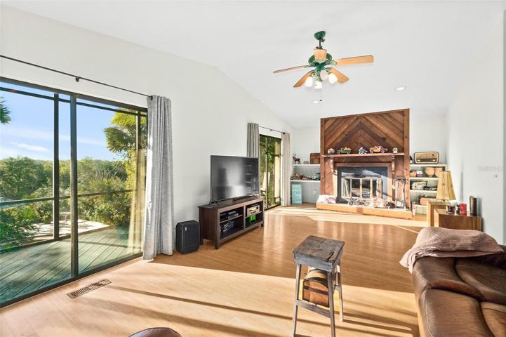 Main upper-level living area with 2 sliding glass doors to covered, screened-in deck.