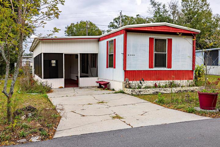 Exterior single wide with driveway and screened carport