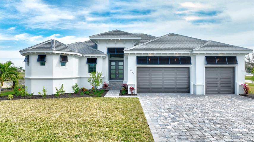 The property boasts impressive curb appeal with a paver driveway and oversized paver front entryway.  Bahama shutters, exposed rafters, multiple roof lines, and transom windows add charm and style.