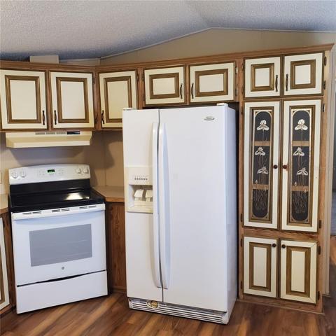 Kitchen with range and ice maker refrigerator