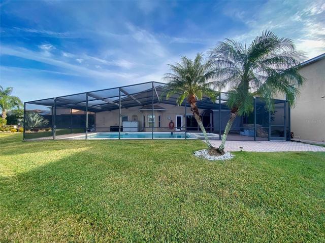 Backyard view. Separate Paver Area beyond Pool Cage