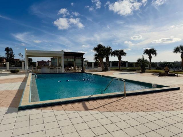 Pool Area looking towards Outdoor Bar area with Additional Seating out of the Sun`