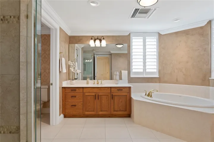 The spacious primary bathroom with double sinks and a soaking tub