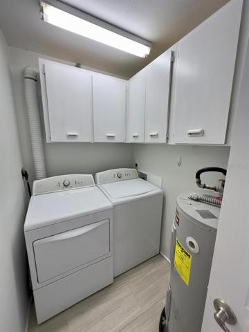 Laundry Room with Washer & Dryer, Cabinets and Hot Water Heater.
