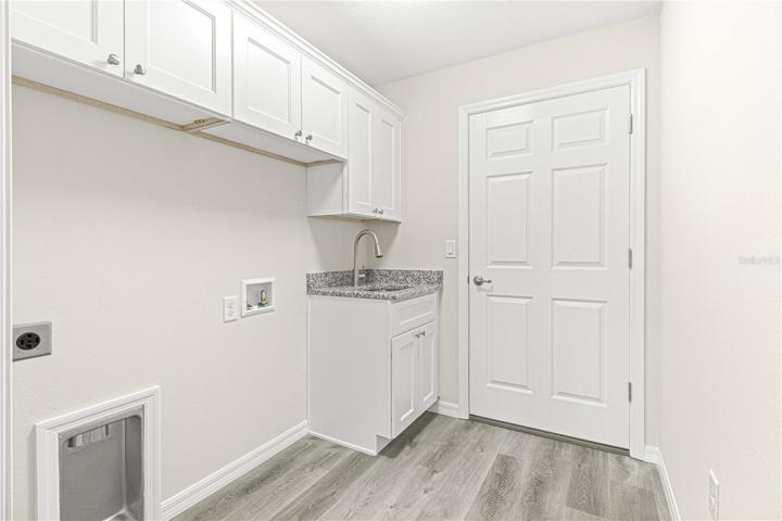 Laundry room with sink and plenty of cabinets for storage