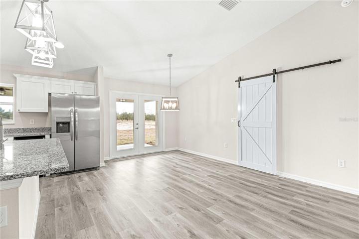 Living area with barn door offering privacy to owners suite
