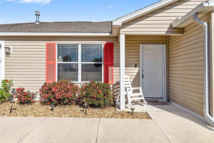 FRONT EXTERIOR shows COVERED FRONT PORCH and colorful azaleas & hibiscus!