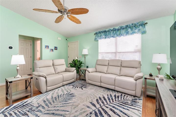 View of LIVING ROOM - Shows CATHEDRAL CEILING, HALLWAY (on L) to BR #2 (front) & BATH #2,  and FRONT ENTRANCE (L center back).