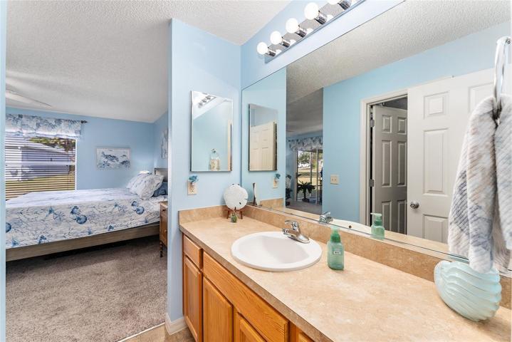 ENSUITE BATHROOM w/ PRIMARY BEDROOM in background