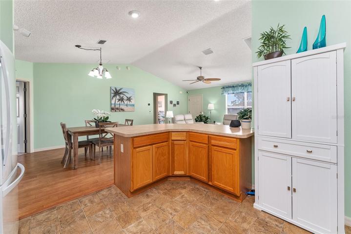 View from back of KITCHEN - Shows BREAKFAST BAR from rear with WHITE PANTRY (on R). Note: CATHEDRAL CEILING over main living area.