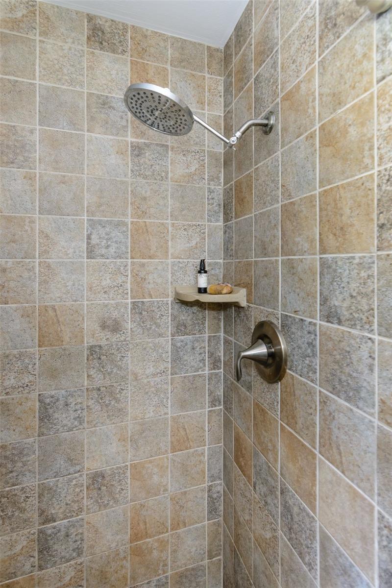 The primary shower features a rain shower head.