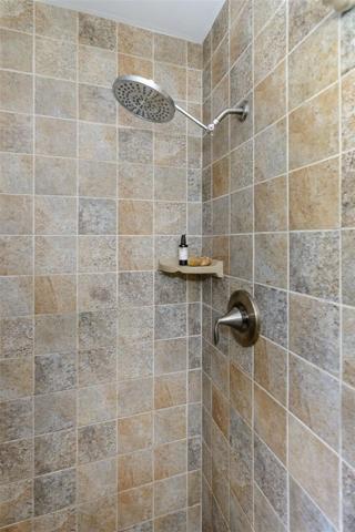 The primary shower features a rain shower head.
