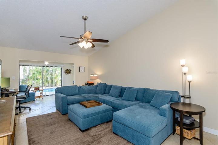 The spacious living room features tile flooring and a ceiling fan.