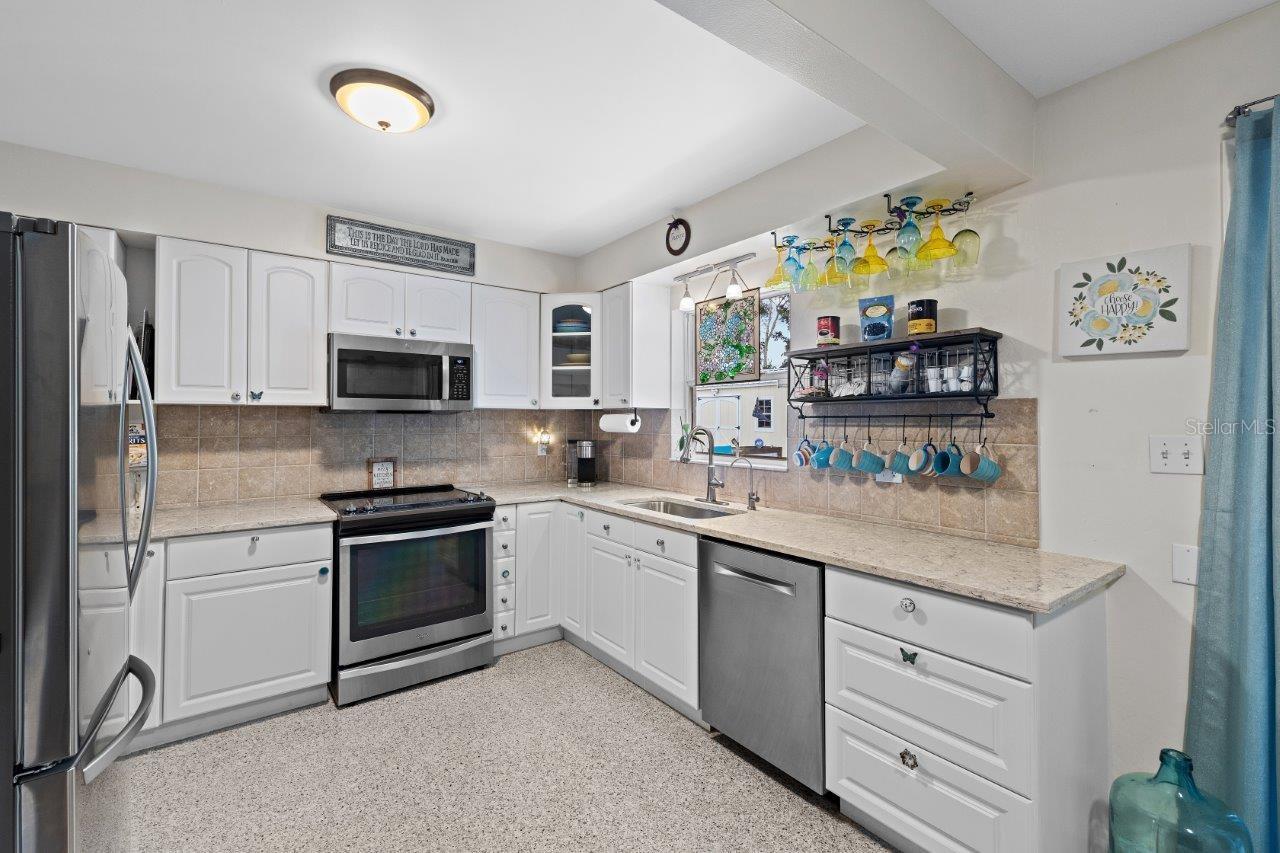 2020 Remodeled Kitchen featuring granite counters, new whirlpool stainless steel appliances, and ample cabinetry.