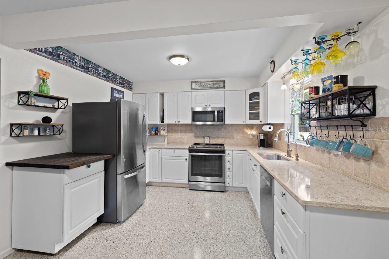 2020 Remodeled Kitchen featuring granite counters, new whirlpool stainless steel appliances, and ample cabinetry.