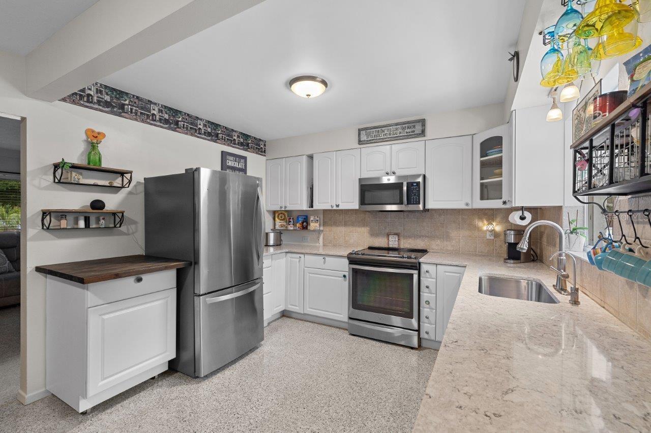 2020 Remodeled Kitchen featuring granite counters, new whirlpool stainless steel appliances, and ample cabinetry.