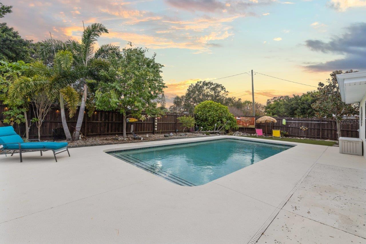 Back yard featuring a heated pool, extended lanai, fenced-in yard, 10'x20' shed, and artificial turf.