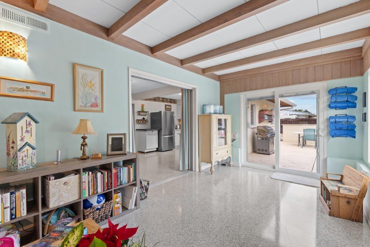 Family room located off the kitchen featuring decorative beams, and 180 degree views of the back yard oasis.