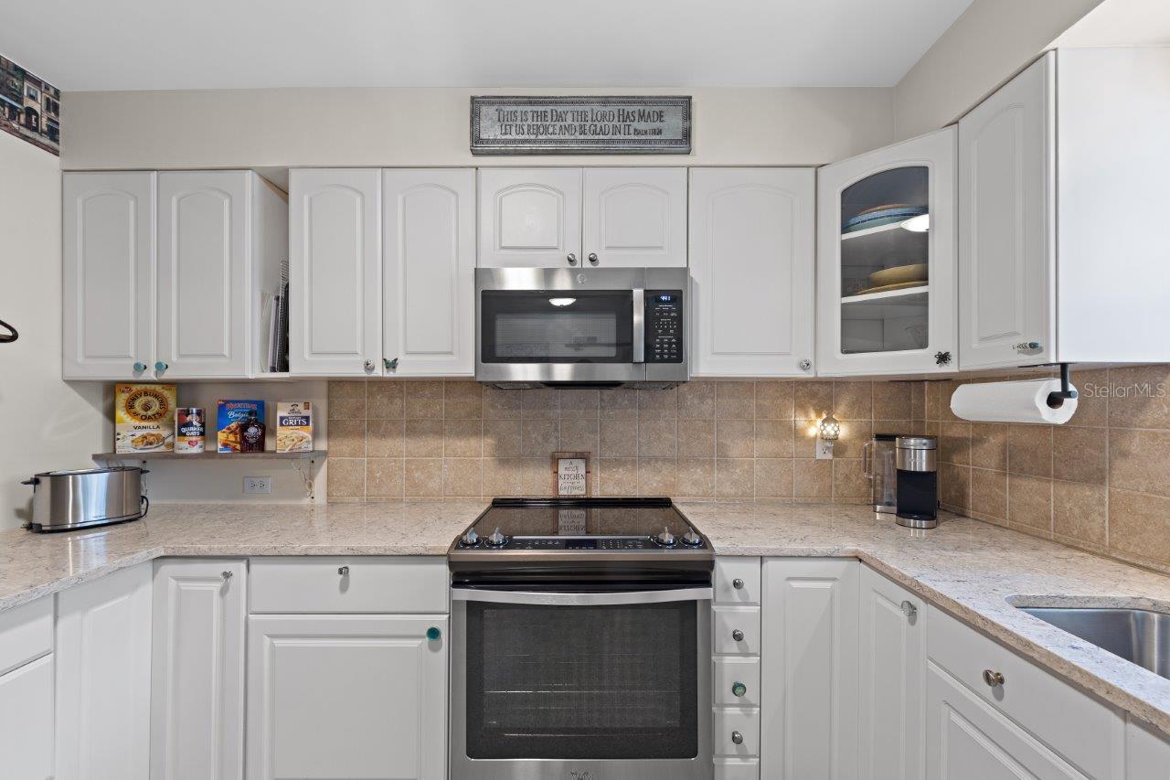 2020 Remodeled Kitchen featuring granite counters, new whirlpool stainless steel appliances, and ample cabinetry.