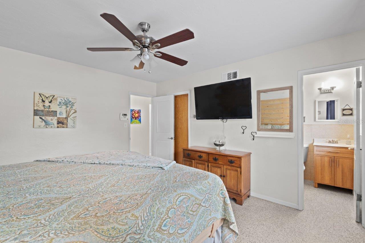 Owner suite featuring a custom accent wall, walk-in closet, and ensuite bathroom.
