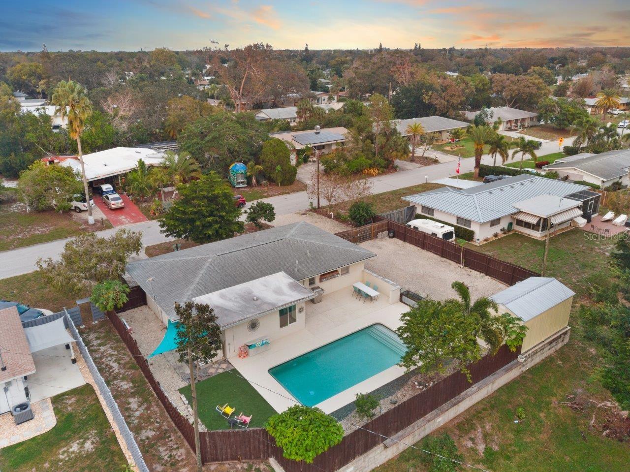 Aerial of the back yard showing the heated pool, extended lanai, and side yard.