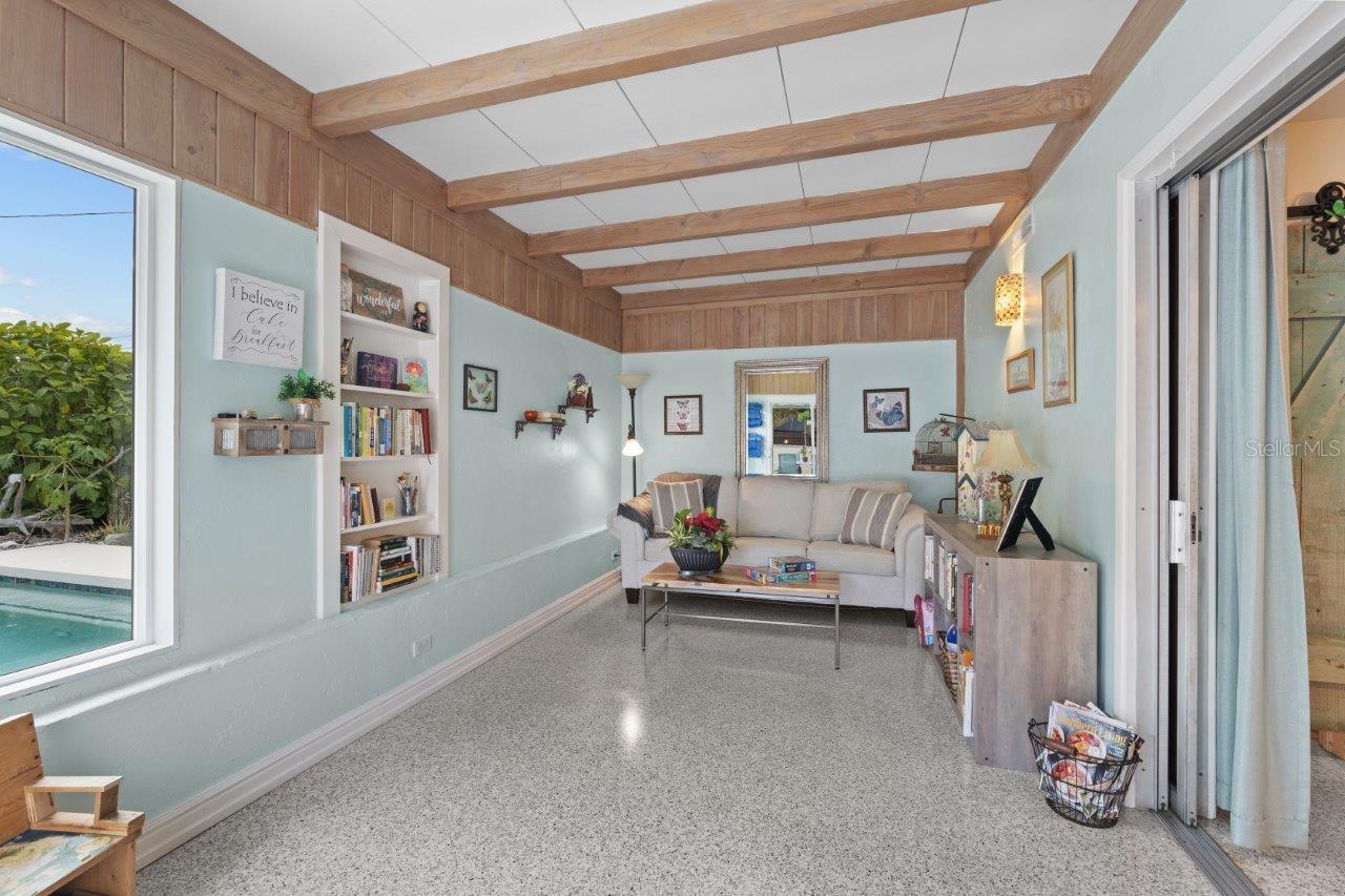 Family room located off the kitchen featuring decorative beams, and 180 degree views of the back yard oasis.