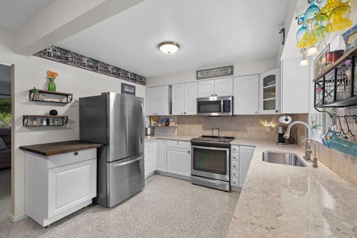2020 Remodeled Kitchen featuring granite counters, new whirlpool stainless steel appliances, and ample cabinetry.