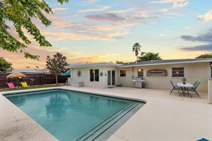 Back yard featuring a heated pool, extended lanai, fenced-in yard, 10'x20' shed, and artificial turf.