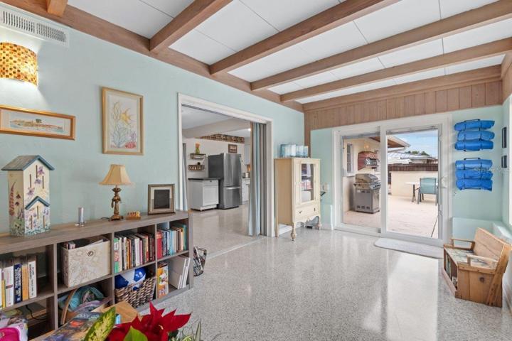 Family room located off the kitchen featuring decorative beams, and 180 degree views of the back yard oasis.