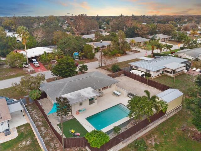 Aerial of the back yard showing the heated pool, extended lanai, and side yard.