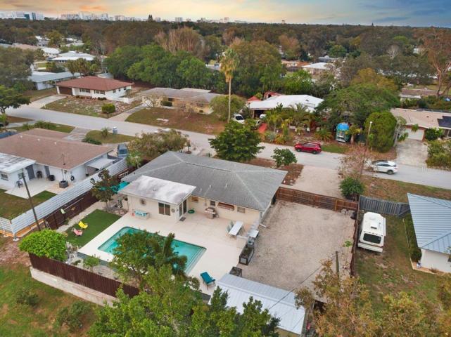 Aerial of the back yard showing the heated pool, extended lanai, and side yard.