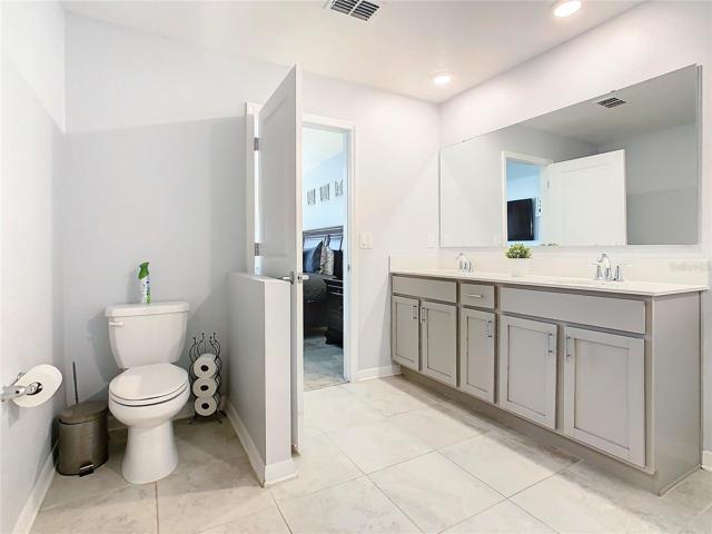 Master Bathroom Toilet Area and Partial View of Double Sink Bath Cabinet.