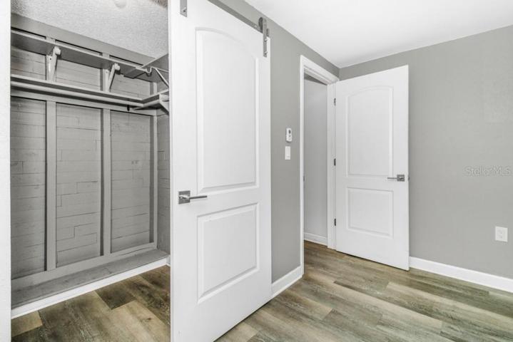 Updated Primary Bedroom with walk-in closet with sliding contemporary barn door and hardware