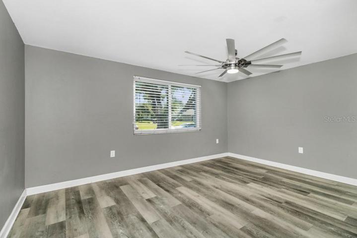 Updated Primary Bedroom with modern LED ceiling fan, sliding contemporary barn door and hardware, and En Suite Bathroom