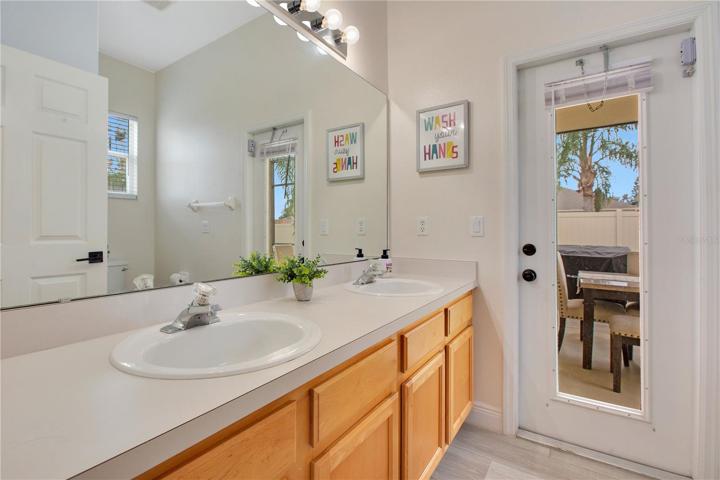 2nd bathroom with double sink leading to pool