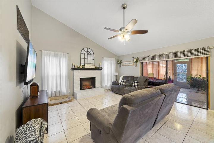The kitchen is open to a light and bright family room with a brick front FIREPLACE centering the space and an OVERSIZED SLIDING GLASS DOOR to access your Florida room!