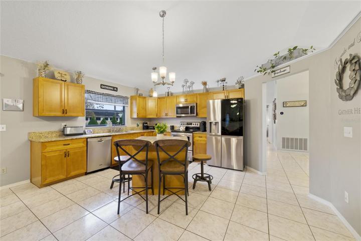 Your kitchen delivers modern cabinetry, GRANITE COUNTERS, a window over the sink for nice natural light, breakfast bar seating on the ISLAND, newer STAINLESS STEEL APPLIANCES and a pantry for ample storage.