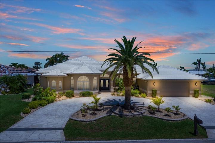 MAGNIFICENT SPACIOUS FOUR BEDROOM HOME WITH STAMPED CIRCULAR CONCRETE DRIVE, SURROUNDED BY LUSH TROPICAL LANDSCAPING