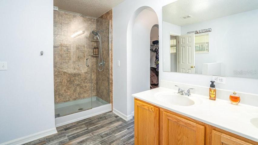 Primary en-suite bath with dual vanities and walk-in shower