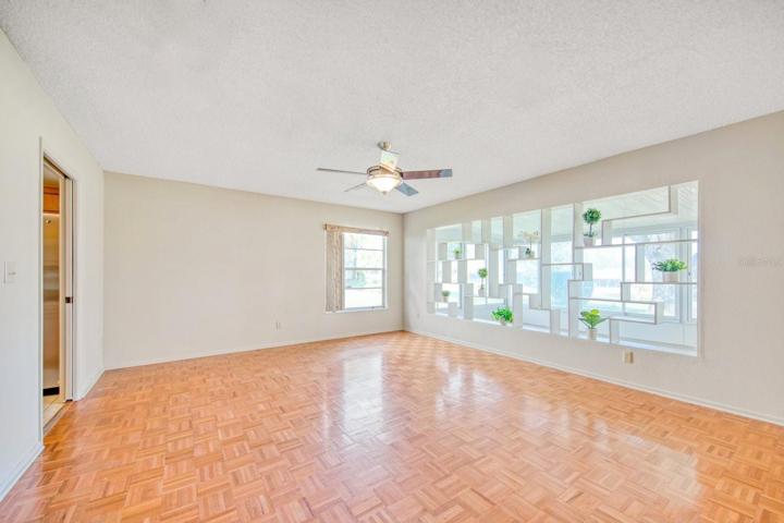 Family room with custom shelving open to Florida room & golf view ~
