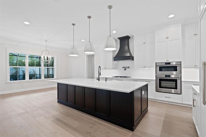 Huge kitchen island with plenty of seating and storage, eat in space overlooking backyard