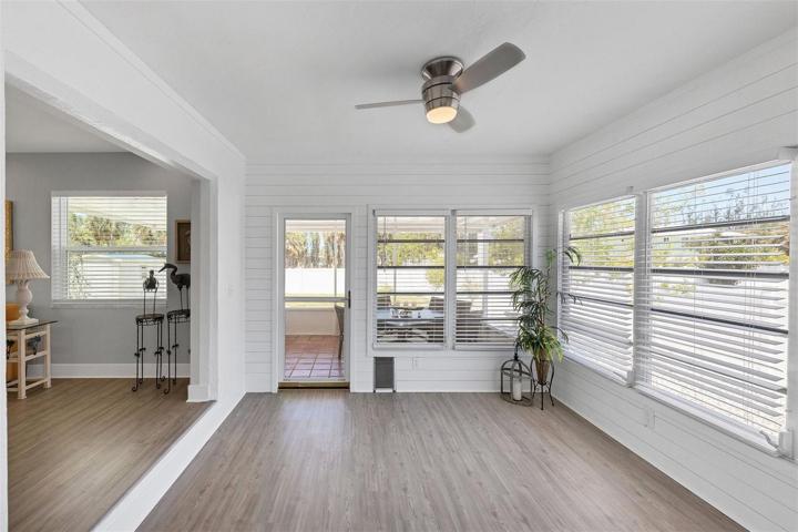 Spacious Florida room with shiplap walls is a perfect space to relax and enjoy the sunshine cascading through the numerous windows.