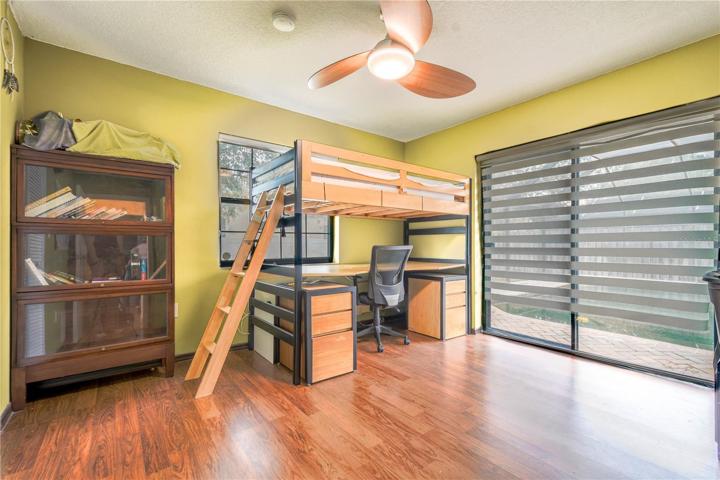 Bedroom 3 features wood laminate flooring, a built-in closet and a ceiling fan.
