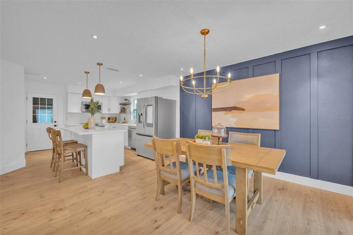 Next to the living area is the open concept dining room with a GORGEOUS gold chandelier and board and batten pattern on the wall.